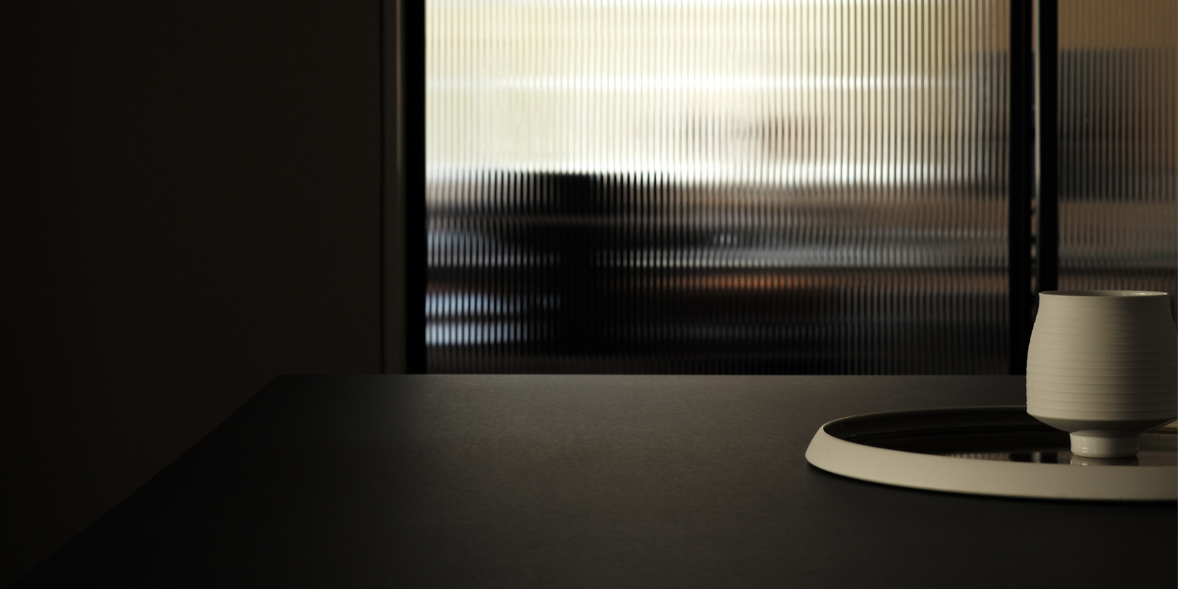 Header of website with porcelain objects in the front and glass door in the back