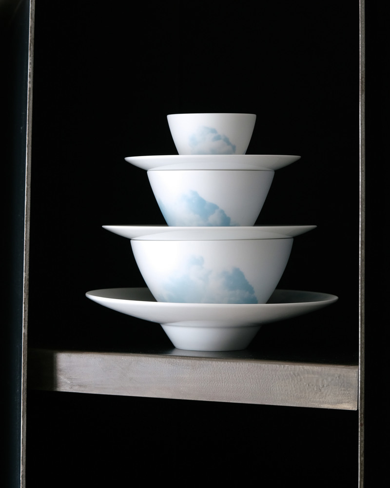 three bowls and three saucers of clouds collection in a black shelf