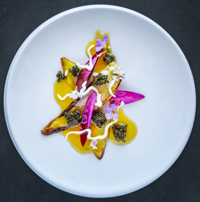 He drapes braised light and purple endive with caviar, flowers and cheese cream on Velvet with its delicate, rough, hand-cut edg